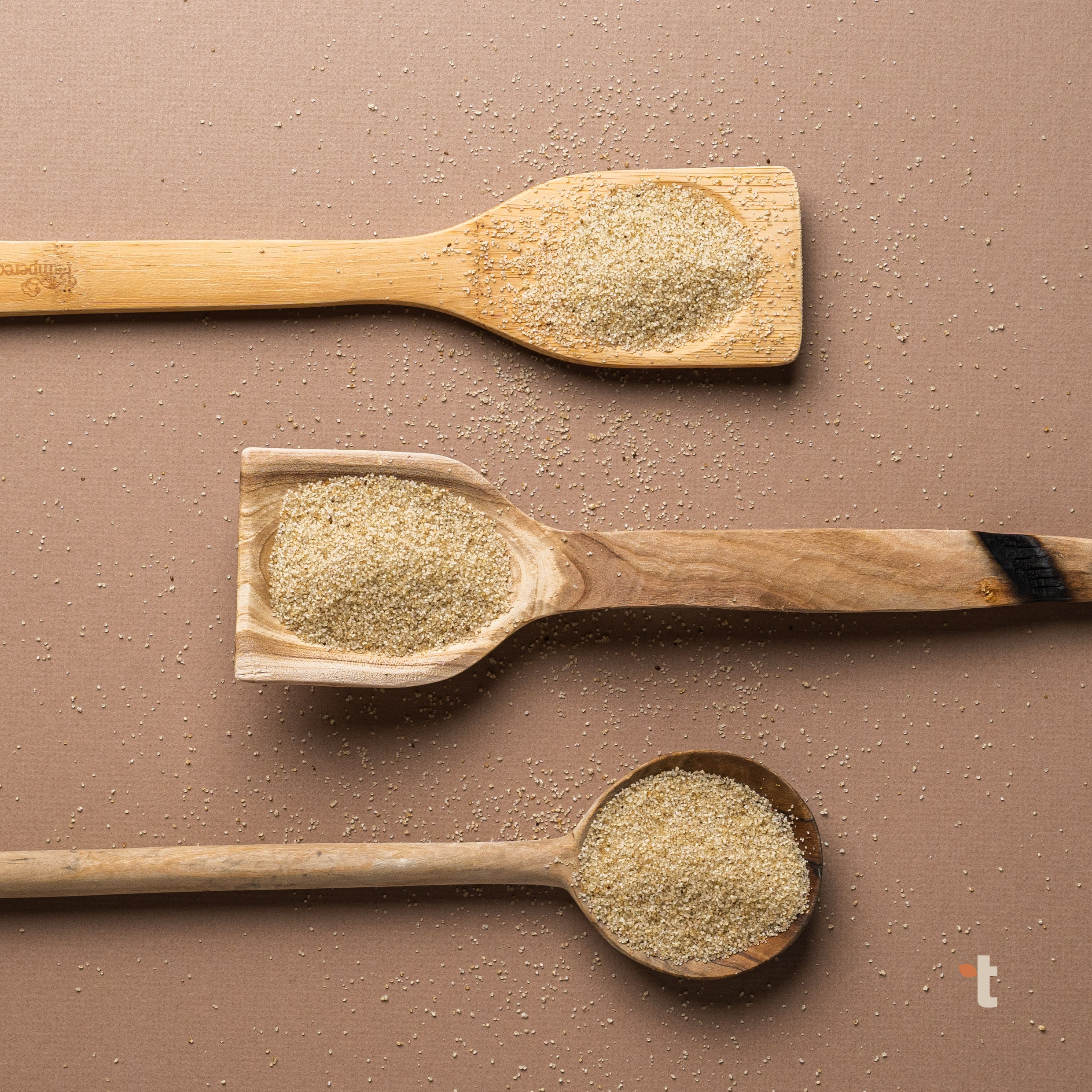 Fonio grain display on three different types of wooden spoons.