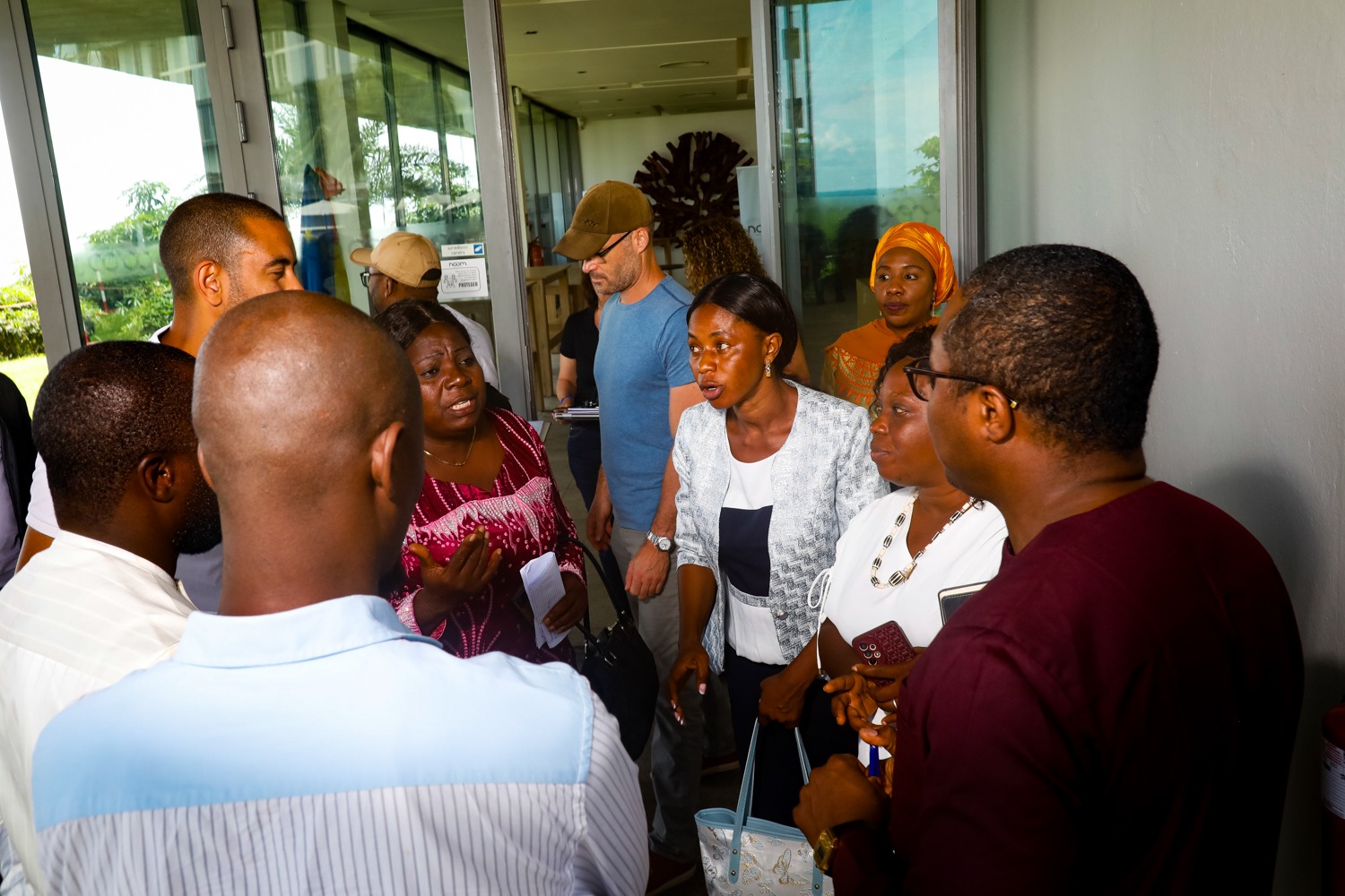 A women leads a discussion with other men and women in front of a meeting room.