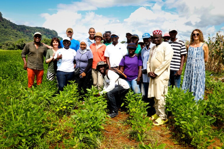 A group of men and women pose for a photo on a farm in Guinea, West Africa