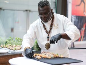 A chef puts the final touches on a plate of assorted desserts