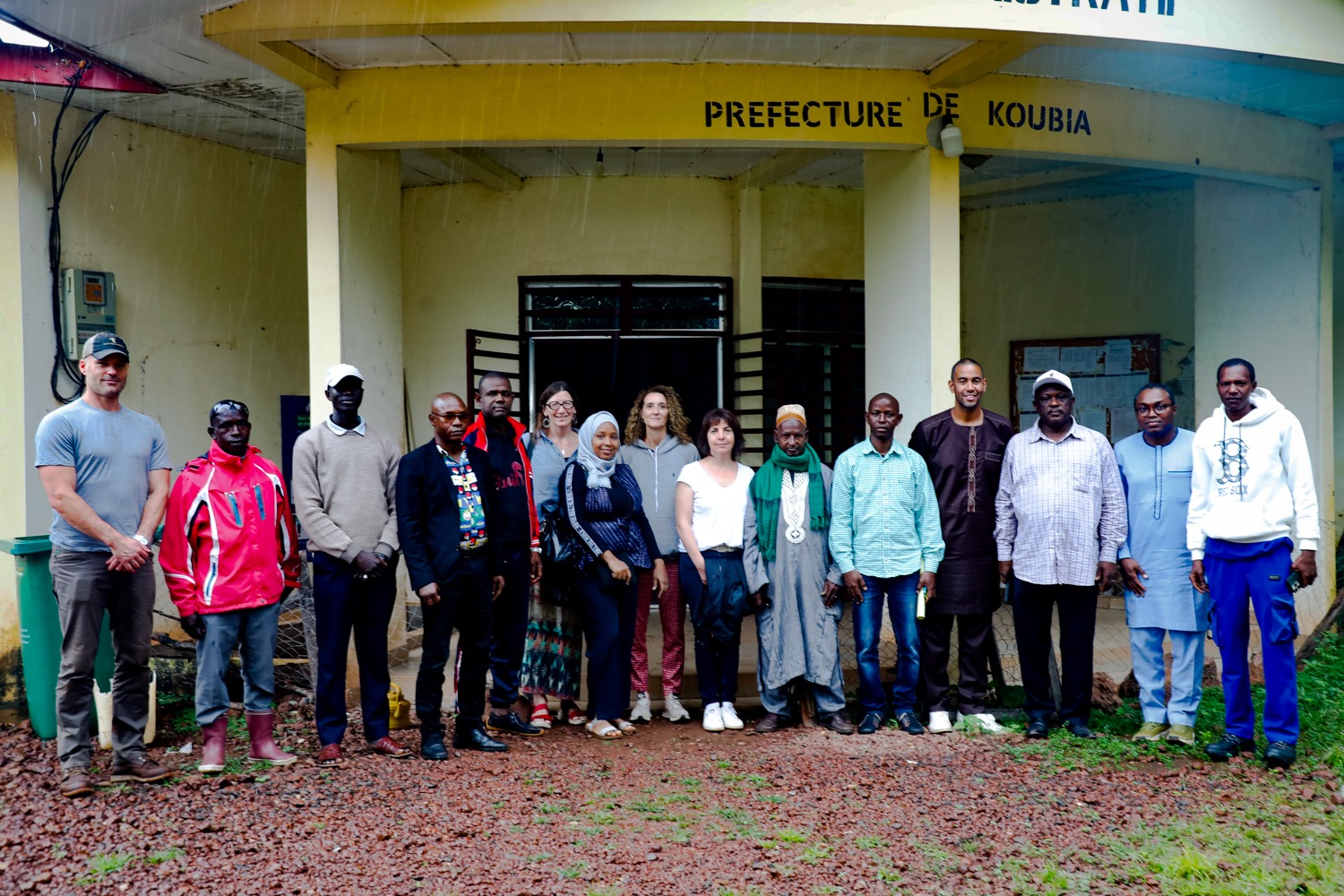A group of men and women pose for a photo in front of a government building