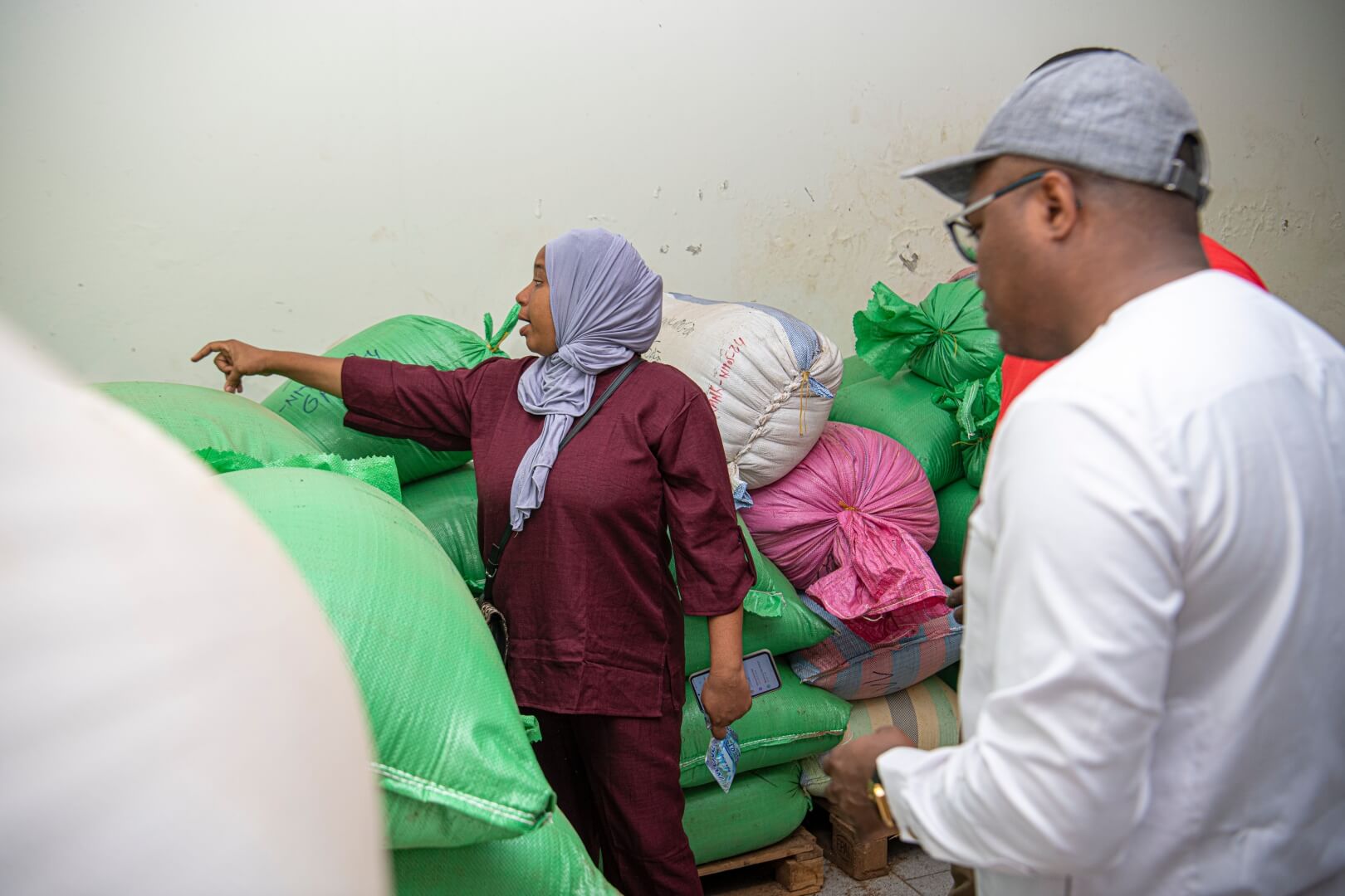 A woman points in front of her while a man in a white shirt observes